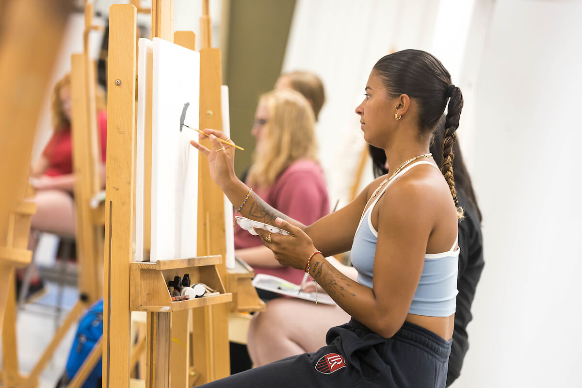 Students painting on canvas during art class