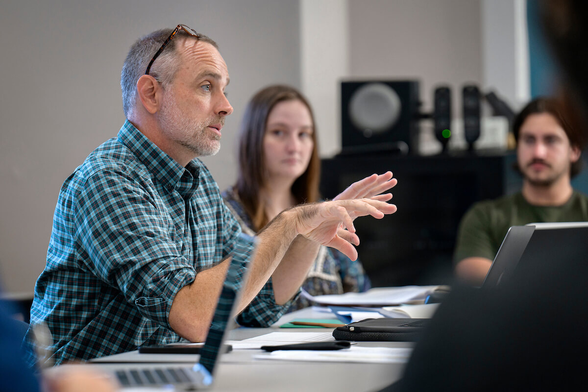 Professor talks with students during class