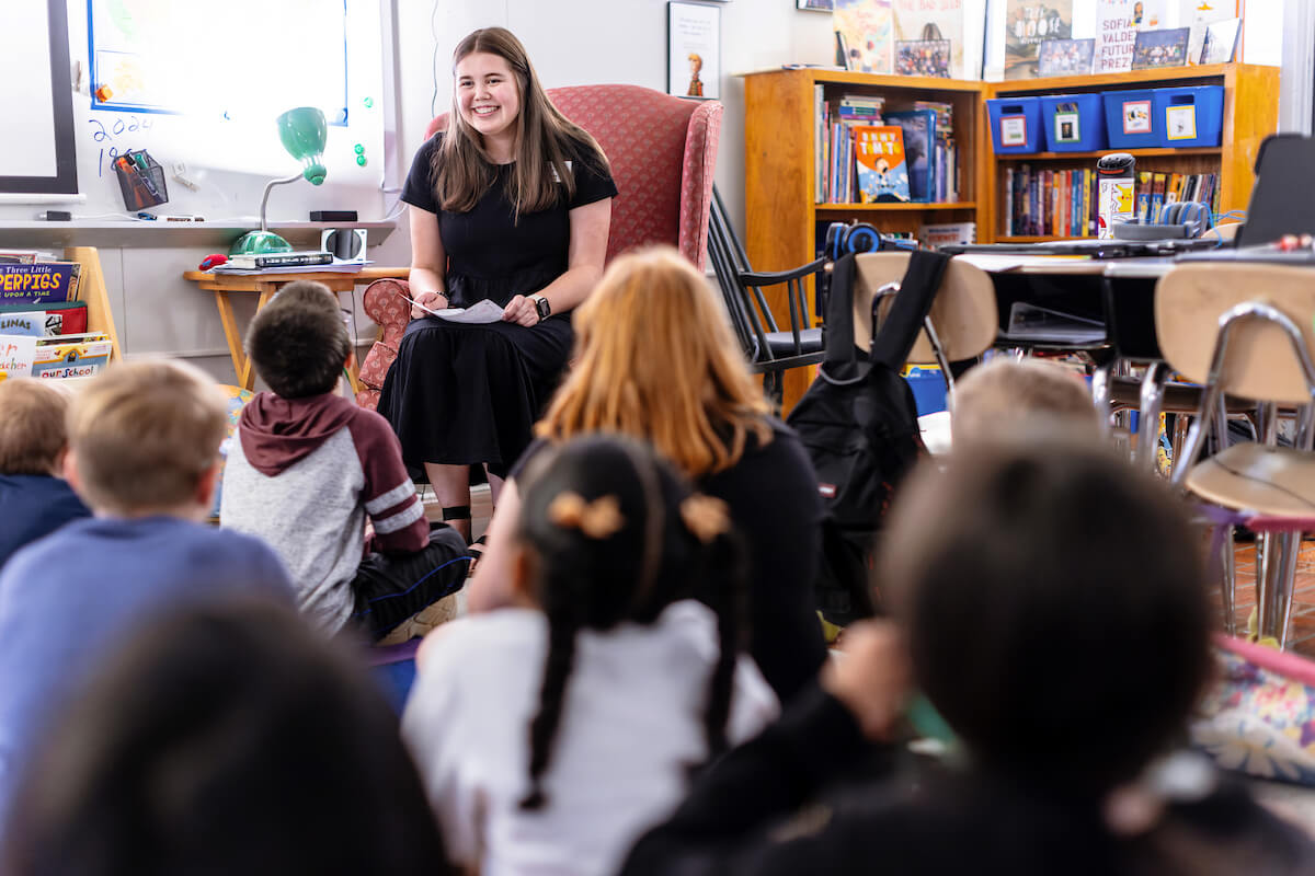 Student teacher reads to young students during class